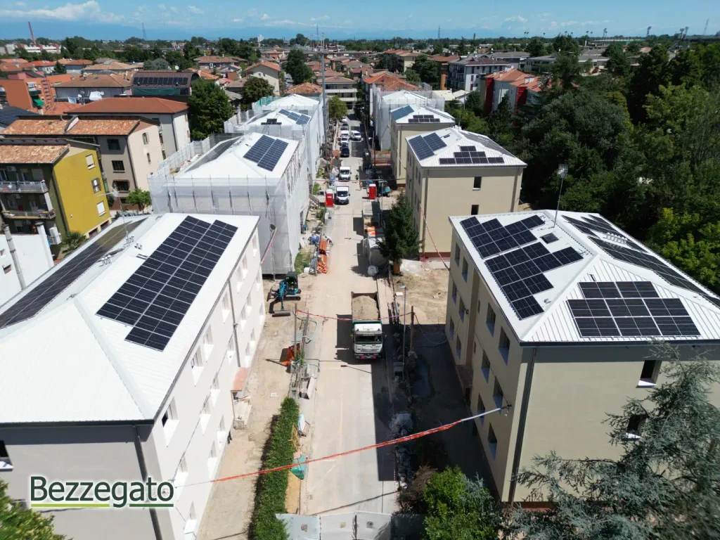 DJI_0520_web | Bezzegato Aerial view of a street with modern houses and solar panels on nearly every rooftop, with construction activity in the middle of the road.